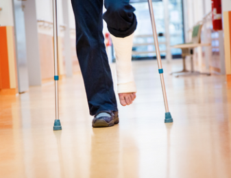 Man walking with crutches and leg cast